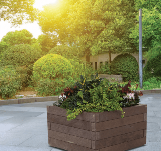 square recycled plastic wood planter on patio with plants and trees surrounding