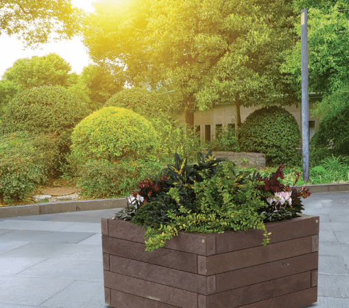 square recycled plastic wood planter on patio with plants and trees surrounding
