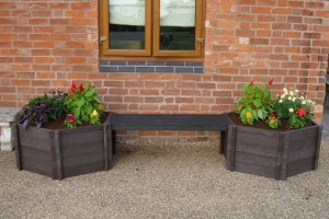 two recycled plastic wood garden planters beside a house wall & window