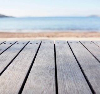 strip of decking overlooking a beach and blue skies