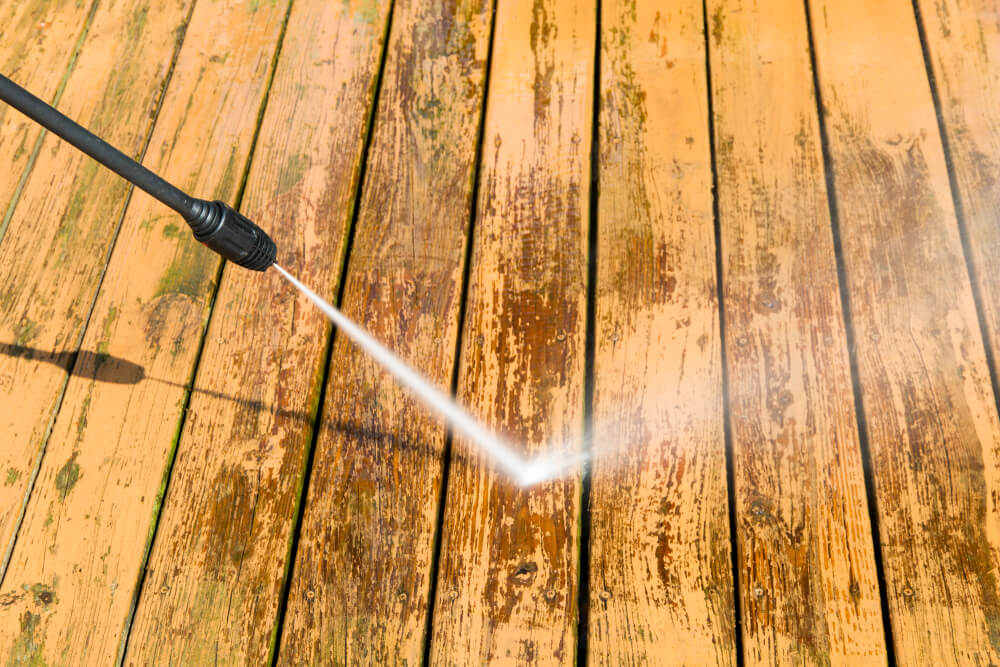 wooden decking being cleaned with pressure washer